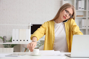 Wall Mural - Young businesswoman working under deadline in office