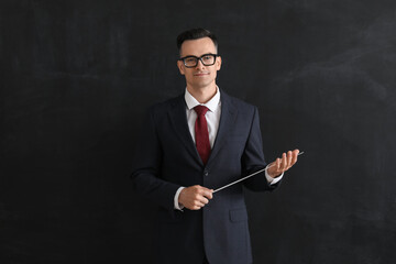 Wall Mural - Male teacher with pointer near blackboard in classroom