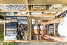 An Unknown Neat Housewife Lays Out Her Underwear In The Drawers Of The Wardrobe. The Concept Of Organizing Space And Storing Clothes.