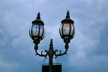 Vintage street lamp. Street light. Two street lamps on a pole against a cloudy sky.