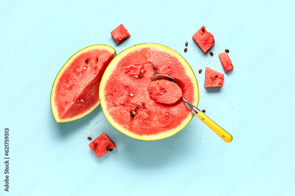 Half of fresh watermelon with pieces and seeds on blue background