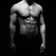 © Acronym - Strong, fit and sporty bodybuilder man over black background