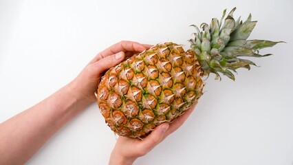 Canvas Print - Ripe juicy pineapple in hands on a white background