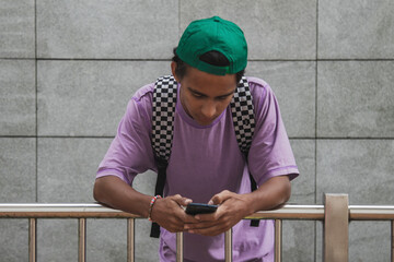 Wall Mural - young teenager in the street using mobile phone