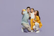 © ViDi Studio - Full body young happy parent mom dad with child kid daughter girl 6 year old wear blue yellow casual clothes do selfie shot on mobile cell phone isolated on plain purple background Family day concept