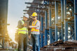 © Phoophinyo - An Asian Team of Engineers and Foremen Inspect Objects at the Construction Site of New Concrete Roads and Bridges forming a Major Urban Infrastructure.