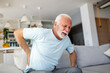 © Graphicroyalty - Senior man, with back pain, touches his back, illustrating sciatica and sedentary lifestyle. Emphasizing spine health and the significance of healthcare and insurance in this stock image.