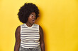 © Asier - African-American woman with afro, studio yellow background being shocked because of something she has seen.