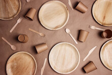 Flat Lay Composition With Eco-friendly Tableware On Brown Paper Background. Bamboo Plates, Paper Cups And Wooden Cutlery.