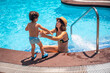 Mother and son in the pool on summer vacation, having fun with their mother