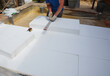 Builder insulating house foundation floor with rigid foam board insulation for warm floor.
