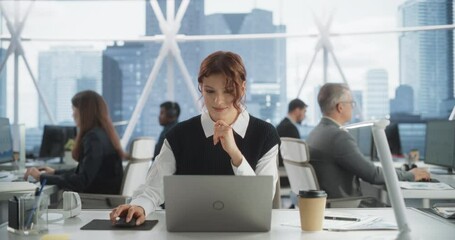 Poster - Beautiful Caucasian Woman Working On Laptop Computer In Bright Office In Urban Skyscraper Office In Downtown. Female Sales Manager Writing Emails To Clients In Workspace With Diverse Colleagues.