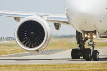 Wall Mural - Hot air behind jet engine of plane at airport. Airplane is taxiing to runway for take off during sunny summer day..