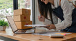 © Natee Meepian - close up woman online store business owner, online shop owner working from home, products for sale on and accepting orders and packing products for customers with courier service