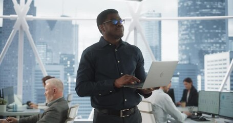 Aufkleber - African American Financial Analyst Walking In Skyscraper Office With Diverse Employees In Downtown. Succeful Black Man Using Laptop Computer To Go Through Tasks And Business Mettings In Hedge Fund.