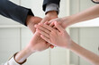 © bigy9950 - Happy united business team joins hands as a sign of business teamwork. stacking hands celebrating victory in office. concept of business success. low angle view.