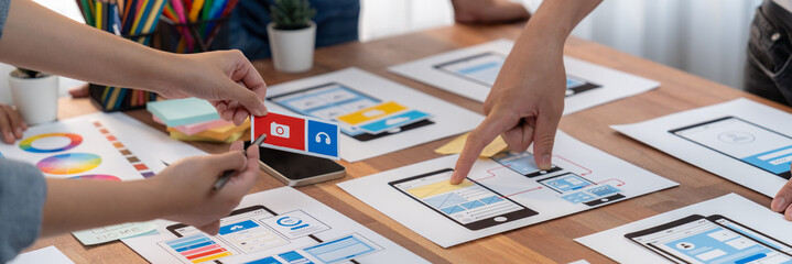 Poster - Panorama shot of front-end developer team brainstorming UI and UX designs for mobile app on paper wireframe interface. User interface development team planning for user-friendly UI design. Scrutinize
