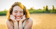 Happy beautiful woman smiling in a wheat field - Delightful female enjoying summertime sunny day outside - Wellbeing concept with confident girl laughing in the nature