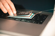 Visualisation of a person trying to prevent phishing and online fraud by holding a leaked credit card on a PC keyboard that is hanging on a fishhook