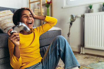 Young African American little girl at home playing video games