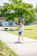 Poster - 新緑の公園で遊ぶ3歳の女の子