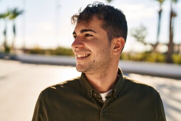 Canvas Print - Young hispanic man smiling confident looking to the side at park