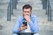 © be free - Disappointed man lost bet. Upset man checking up betting results in mobile phone. Betting online