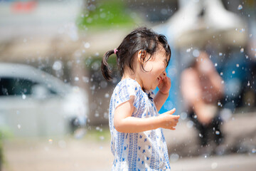 Poster - 広場の噴水で水遊びしている3歳の女の子