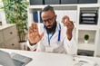 © Krakenimages.com - African american man working at dietitian clinic holding doughnut with open hand doing stop sign with serious and confident expression, defense gesture