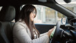 © Krakenimages.com - Young beautiful hispanic woman cleaning steering wheel sitting on car at street