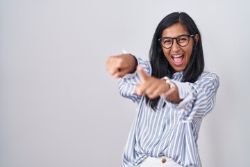 Sticker - Young hispanic woman wearing glasses pointing to you and the camera with fingers, smiling positive and cheerful