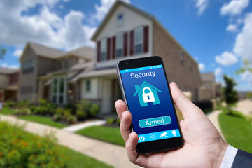 Poster - Smartphone with home security app in a hand on the building background.