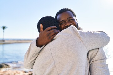 Canvas Print - Man and woman couple hugging each other standing at seaside