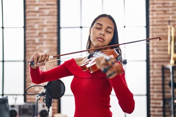 Canvas Print - Young african american woman musician playing violin at music studio