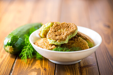 Wall Mural - fried zucchini pancakes with herbs, in a plate .