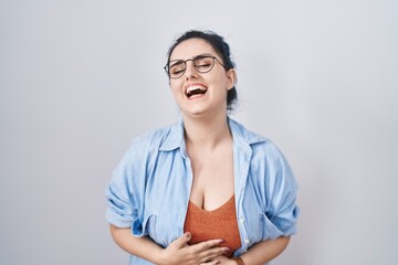 Canvas Print - Young modern girl with blue hair standing over white background smiling and laughing hard out loud because funny crazy joke with hands on body.