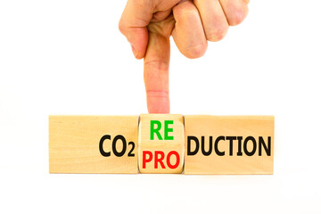 Wall Mural - CO2 production or reduction symbol. Concept word CO2 production reduction on a wooden block on a beautiful white background. Businessman hand. Business ecological and CO2 changes concept. Copy space.