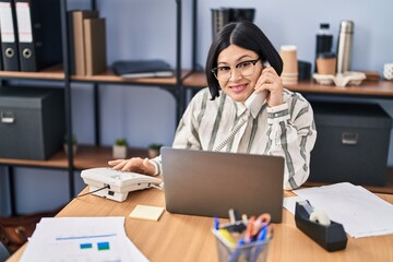 Wall Mural - Young chinese woman business worker talking on the telephone at office