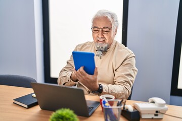 Wall Mural - Middle age grey-haired man business worker using touchpad and laptop at office