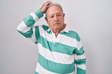 Poster - Senior man with grey hair standing over white background confuse and wondering about question. uncertain with doubt, thinking with hand on head. pensive concept.