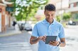 © Krakenimages.com - African american man smiling confident using touchpad at street