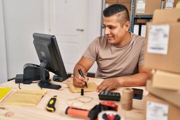 Sticker - Young latin man ecommerce business worker writing on package at office