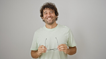 Sticker - Young hispanic man smiling confident taking glasses off over isolated white background