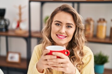 Sticker - Young woman drinking coffee sitting on table at home