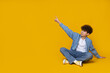 Teenager pointing finger up on yellow background