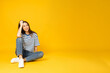 © Atlas - A young woman in a striped t-shirt sits on a yellow background, place for text