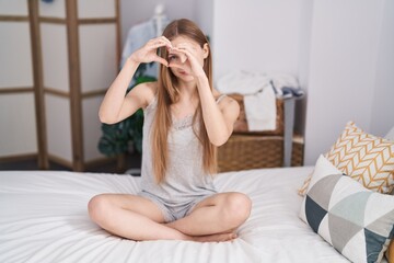 Poster - Young caucasian woman doing heart gesture sitting on bed at bedroom