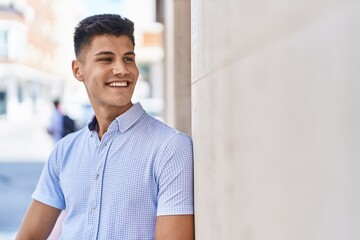 Wall Mural - Young hispanic man smiling confident looking to the side at street