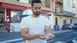 © Krakenimages.com - Young hispanic man with serious face wearing watch at street