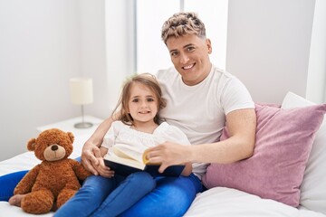 Wall Mural - Father and daughter father and daughter reading book holding teddy bear at bedroom